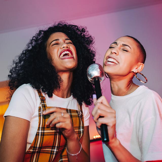 Two friends singing karaoke.