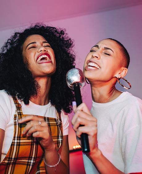two woman singing karaoke 