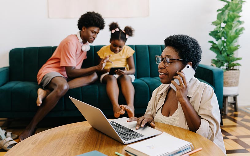 mom at home with computer and kids in the background