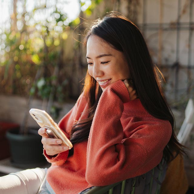 Woman looking at her phone on the patio
