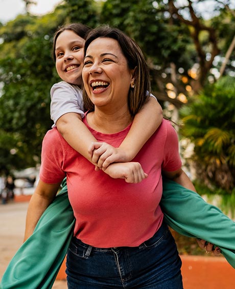 mom giving daughter a piggyback ride