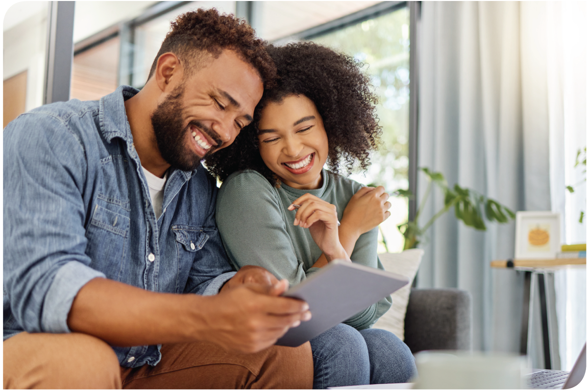 Happy couple using a tablet and going through documents